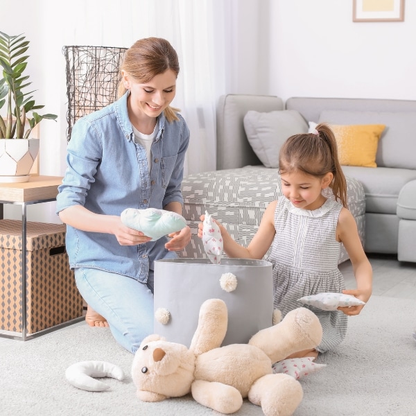 A client picking up toys in preparation for her recurring cleaning service.