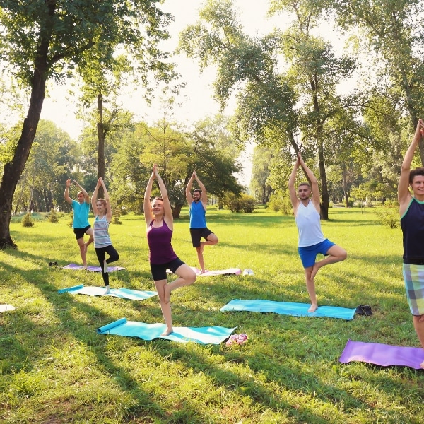 A group of adults doing yoga in a park.